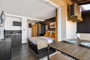 カップ・ダグドにあるVIEW port venus naturisteのベッドとキッチン付きの小さなホテルルームです。