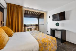 a hotel room with a bed and a balcony at VIEW port venus naturiste in Cap d'Agde
