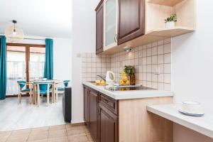 a kitchen with a sink and a table with chairs at Jaśmin in Rowy