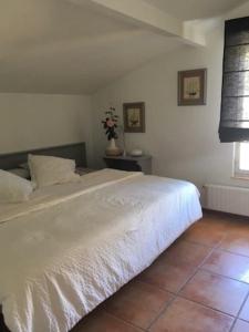 Schlafzimmer mit einem weißen Bett und Fliesenboden in der Unterkunft Casa de los Belgas in Frama