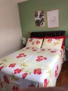 um quarto com uma cama com flores vermelhas em Apartamento Centro Histórico de Petrópolis 200Mbps de internet em Petrópolis