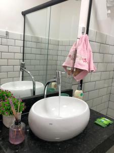 a bathroom with a sink and two mirrors at Apartamento Centro Histórico de Petrópolis 200Mbps de internet in Petrópolis +15 photos