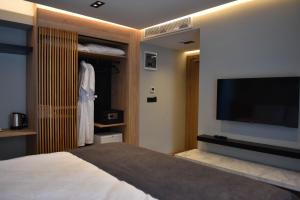 a bedroom with a bed and a flat screen tv at Casa Luxury Hotel in Göcek
