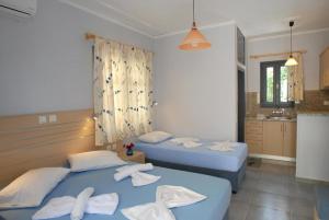 Dos camas en una habitación de hotel con toallas. en Irene ROOMS & STUDIOS PETRA, en Petra
