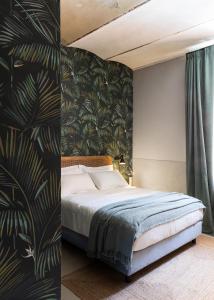 ein Schlafzimmer mit einem Bett und einer tropischen Tapete in der Unterkunft Antica Dimora Le Misure in Cervia