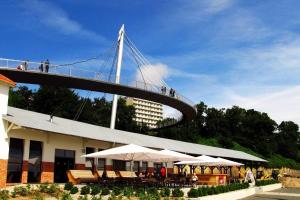 a suspension bridge over a building with tables and umbrellas at Ferienwohnung Seebrise in Sassnitz