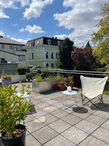 um pátio com uma cadeira branca e uma mesa e algumas plantas em Villa V - zwischen Kultur und Natur em Viersen