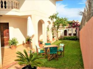 patio ze stołem i krzesłami na podwórku w obiekcie *****Villa de Món max. 8 Personen, Meerblick + Pool w mieście Cala Anguila