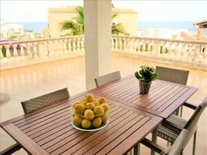 un piatto di frutta su un tavolo in legno sul balcone di *****Villa de Món max. 8 Personen, Meerblick + Pool a Cala Anguila