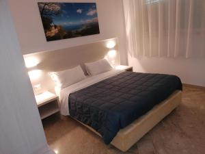 a bedroom with a large bed with two night stands at Zibibbo Beach Apartments - Trapani in Trapani