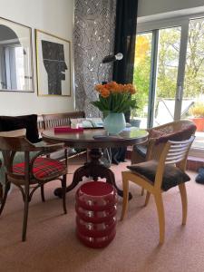 a living room with a table with a vase of flowers on it at Villa V - zwischen Kultur und Natur in Viersen