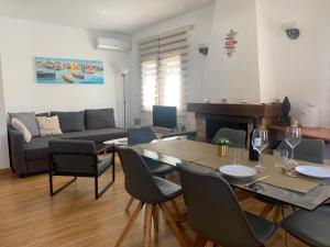 ein Wohnzimmer mit einem Tisch, Stühlen und einem Sofa in der Unterkunft Villa Sonrisa de Oro - private swimming pool in Miami Platja