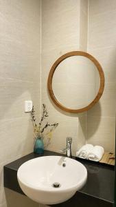 a bathroom with a white sink and a mirror at Lacovy Home Hội An in Hoi An