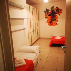 ラ・スペツィアにあるSTELLA MARINAのベッド2台と赤いテーブルが備わる小さなお部屋です。