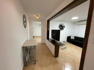 a living room with a television and a couch at אל מול חרמון- דירה באווירה כפרית עם נוף לחרמון in Sheʼar Yashuv