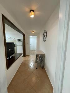 a hallway with a table and a clock on a wall at אל מול חרמון- דירה באווירה כפרית עם נוף לחרמון in Sheʼar Yashuv