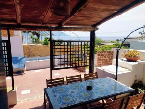 patio con mesa y sillas en el balcón en Il Villaggio Eoliano, en Santa Marina Salina
