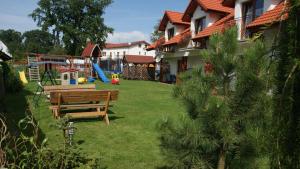 a yard with a wooden bench and a playground at Jaśmin in Rowy +34 photos