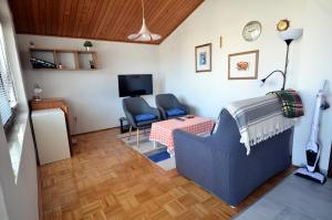 een kamer met een bed, een stoel en een tv bij Blue Sky Apartment Primosten in Primošten