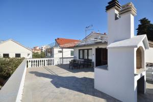 een patio in een huis met een wit hek bij Blue Sky Apartment Primosten in Primošten