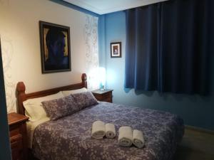 a bedroom with a bed with two slippers on it at Ático de Josetxu in Águilas +16 photos