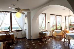 a dining room with tables and chairs and windows at Up Hotel in Naples