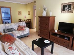a living room with a couch and a tv at Ático de Josetxu in Águilas