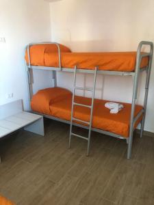 two bunk beds in a room with an orange mattress at LA CASA DEL BORGO in Petralia Soprana