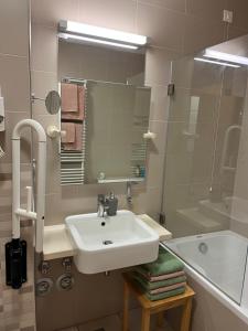 y baño con lavabo, bañera y espejo. en Golden Fox Apartment Pohorje, en Maribor