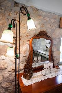 a mirror on top of a wooden table with a lamp at La casa di Bella a tradional stone house with barbecue in Kariá +67 photos