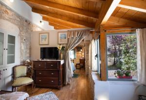 a living room with a dresser and a window at La casa di Bella a tradional stone house with barbecue in Kariá