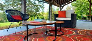 a table and two chairs on a rug on a patio at maison d'hôtes Le Courty in Blousson-Sérian