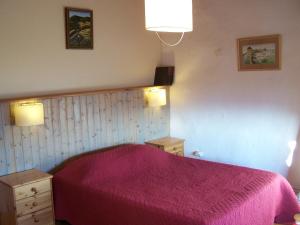 una camera con un letto e una coperta rosa di Gîte de Chapelèche Les Châtaigniers a Gluiras