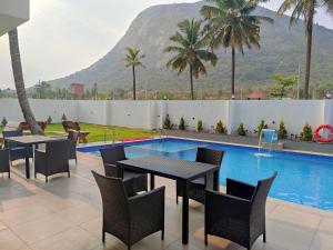 a patio with tables and chairs next to a swimming pool at SILVER CLOUD in Nandigunda