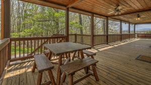 un portico in legno con tavolo da picnic e panche di Tranquility a Blue Ridge