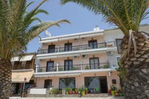 un edificio con palmeras delante en Hotel Akrogiali en Ouranoupoli