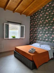 Un dormitorio con una cama con una pared con pájaros. en Profumo di Zagara, en Fiumefreddo di Sicilia