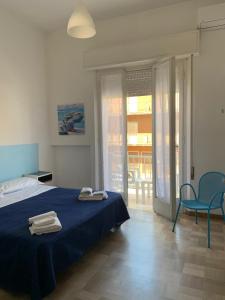 リミニにあるHotel Villa Eneaのベッドルーム(青いベッド1台、青い椅子付)