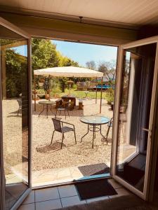 an open patio door with a table and an umbrella at Le Portanel in Eymet