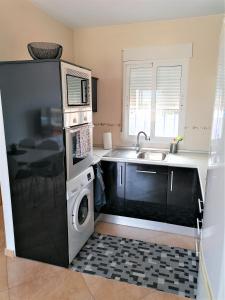 cocina con nevera y lavadora en AL06- Modern 3 bed Duplex, close to beach in El Alamillo, en Puerto de Mazarrón