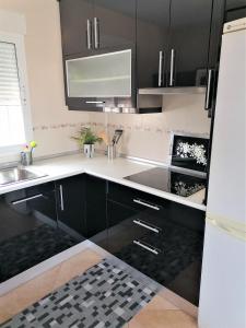 una cocina con armarios negros y fregadero en AL06- Modern 3 bed Duplex, close to beach in El Alamillo, en Puerto de Mazarrón