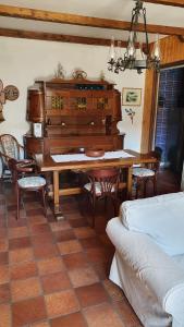 a living room with a table and a piano at Dimora San Vincenzo in Pescocostanzo