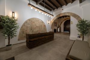 Ancient Knights Luxury Suites في بلدة رودس: غرفة معيشة مع أريكة وجدار من الطوب