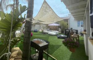 a backyard with green grass and a palm tree at Sunset Wave - STAGNONE KITESURF VILLAGE in Birgi Vecchi