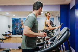 a man and a woman on a treadmill in a gym at Gran Hotel Don Manuel in Cáceres