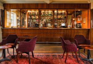 un ristorante con sedie e un bar con bancone di The Aviator Hotel a Northampton