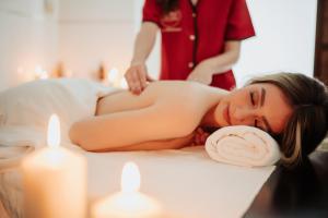 a woman getting a massage at a spa with candles at Gran Hotel Don Manuel in Cáceres