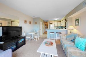 a living room with a couch and a tv and a table at Hidden Harbour 312C in Ocean City