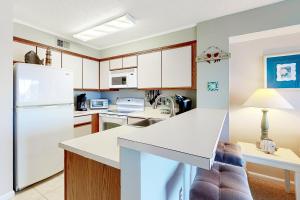 a kitchen with white cabinets and a white refrigerator at Hidden Harbour 312C in Ocean City