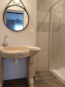 ein Bad mit einem Waschbecken und einem Spiegel in der Unterkunft Chez Catherine et Laurent in Ploemeur